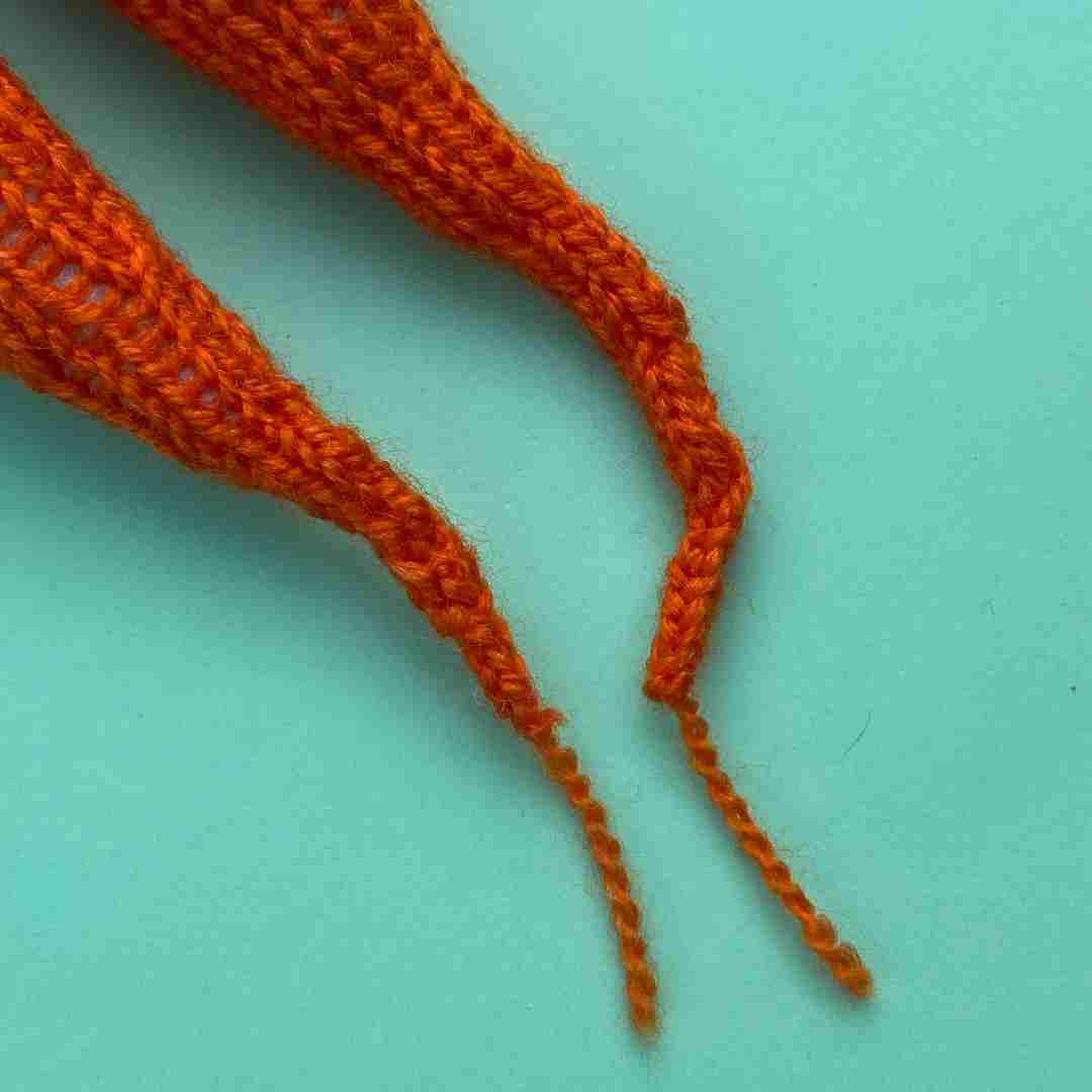 Close up of knitted carrot tips in orange yarn