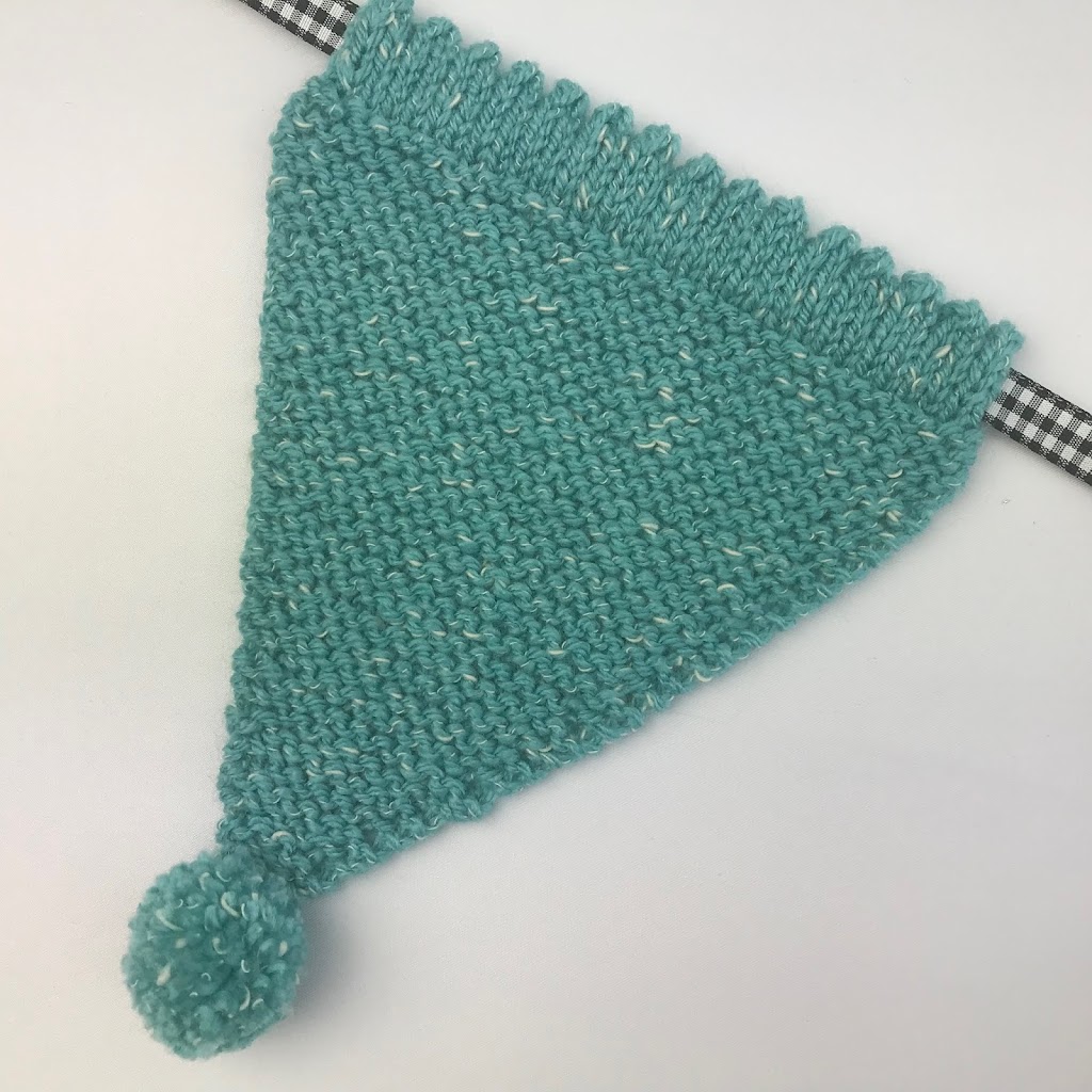 Knitted bunting triangle in garter stitch and green flecked yarn