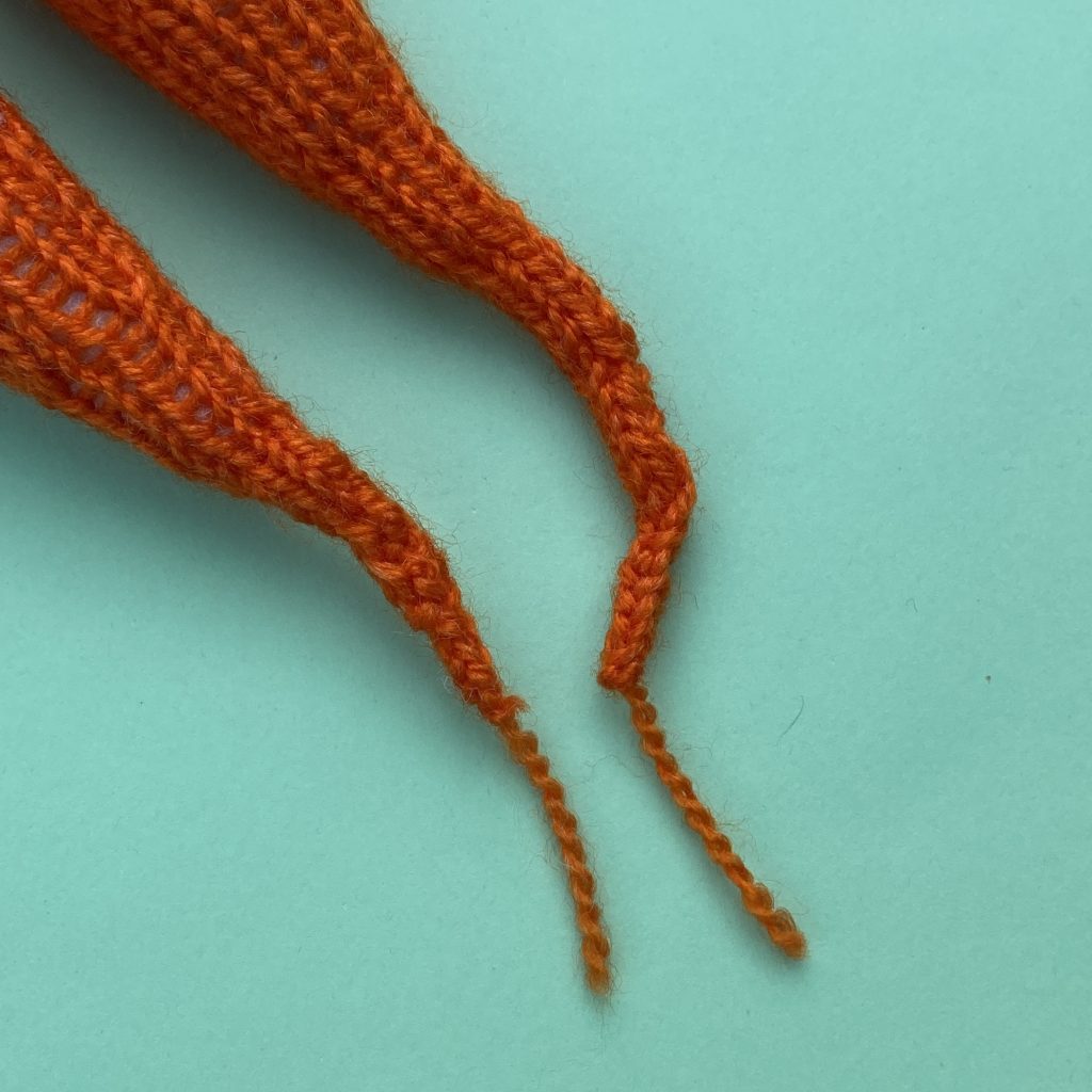 knitted carrots close up of tips. Made from free knitted carrot pattern