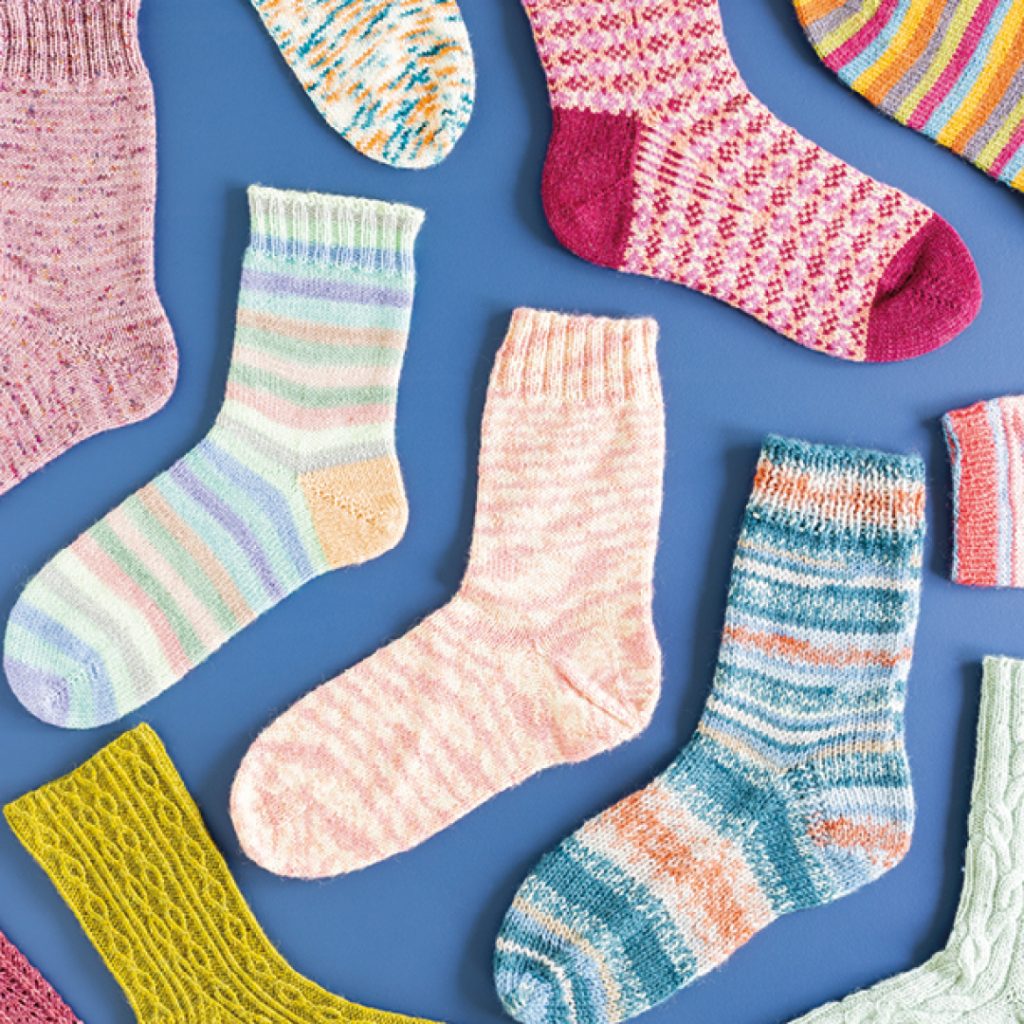 A collection of hand knitted socks with various different hand dyed yarns.
