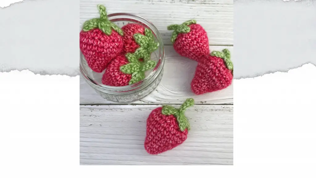 6 crochet strawberries made from free crochet pattern, with 3 in a glass bowl and 3 scattered around.