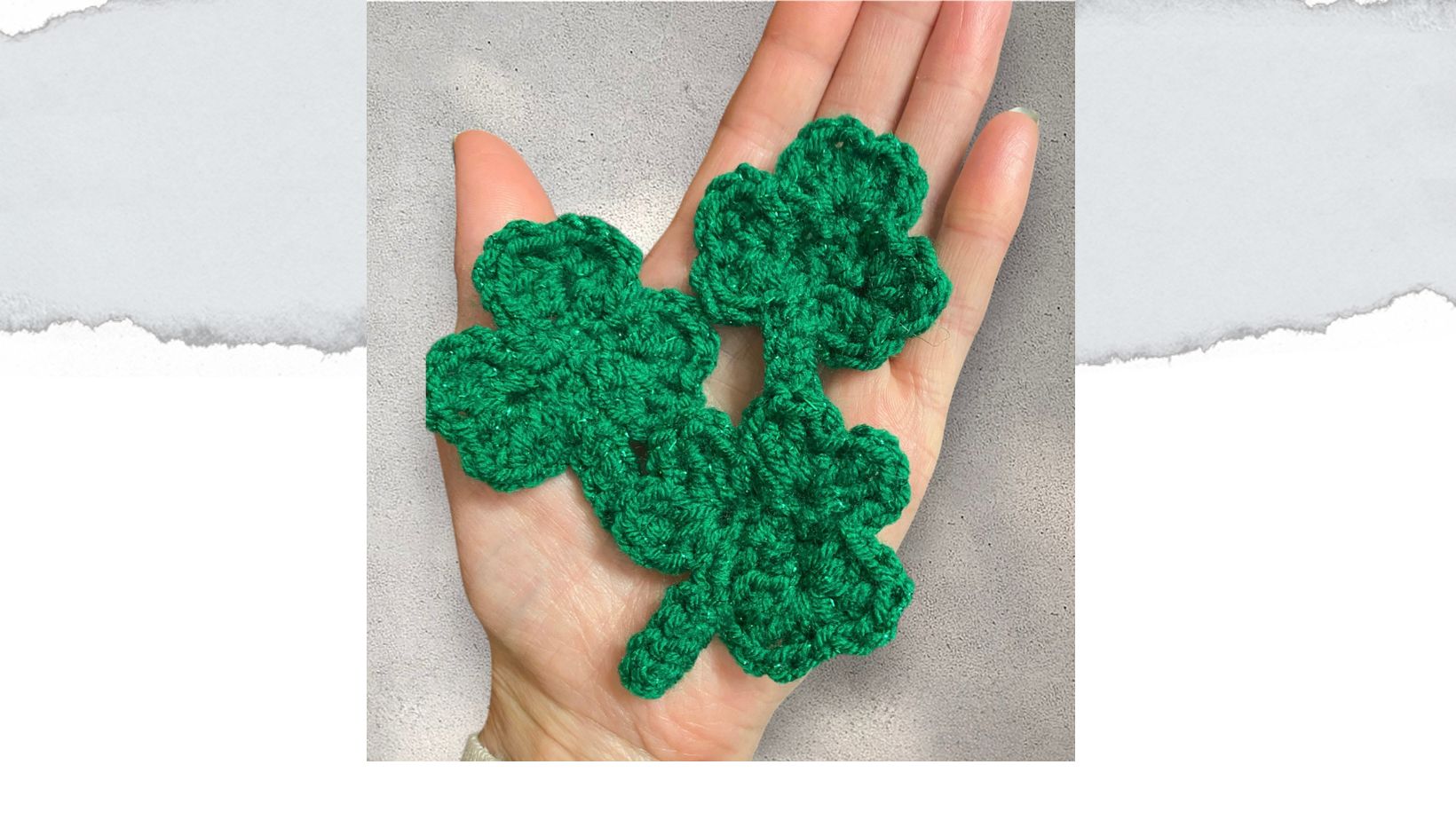 hand holding 3 crochet shamrocks, in green yarn