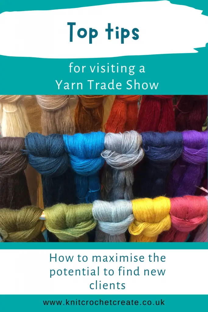 Post showing colourful yarn on display at a yarn trade show. Skeins of hand dyed yarn, hanging over poles.