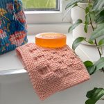 Basketweave stitch for crochet used in a washcloth in peach cotton yarn.