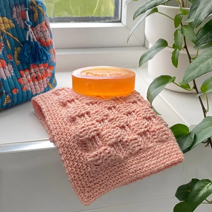 Basketweave stitch for crochet used in a washcloth in peach cotton yarn.