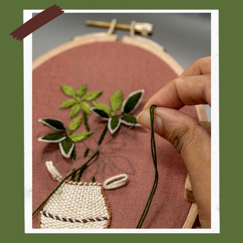 An embroidery hook with an embroidered plant and flowers