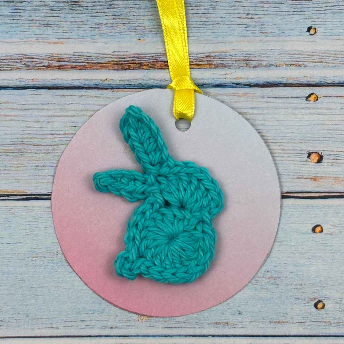Tiny bunny motif crocheted in Teal, on a gift tag to use for gift wrapping.