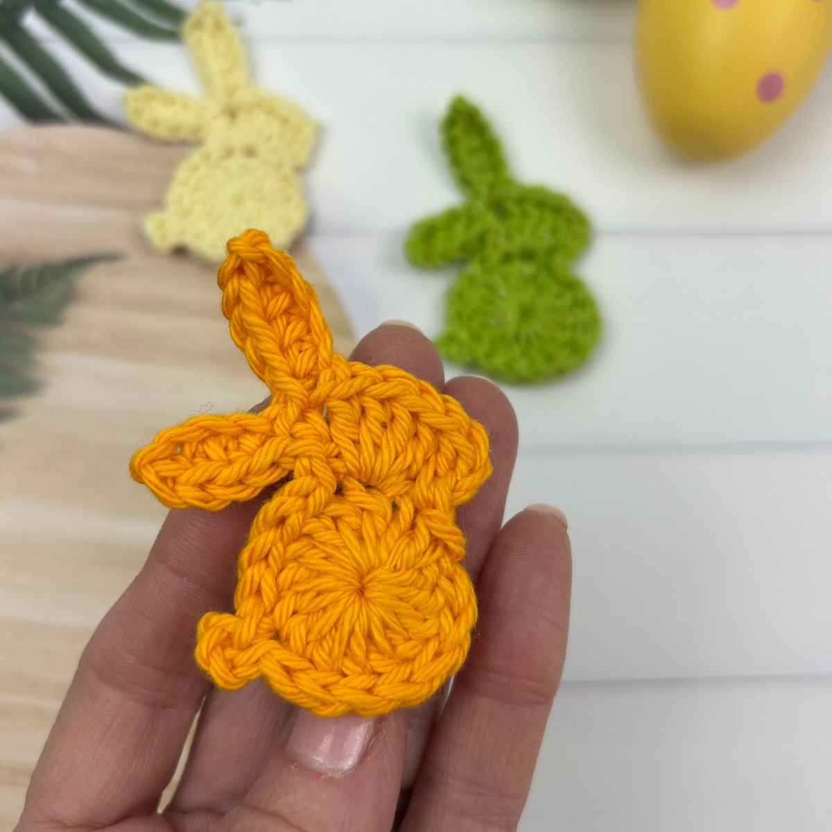 3 crochet bunny motifs made from free pattern, shown in lemon, orange and green yarn.