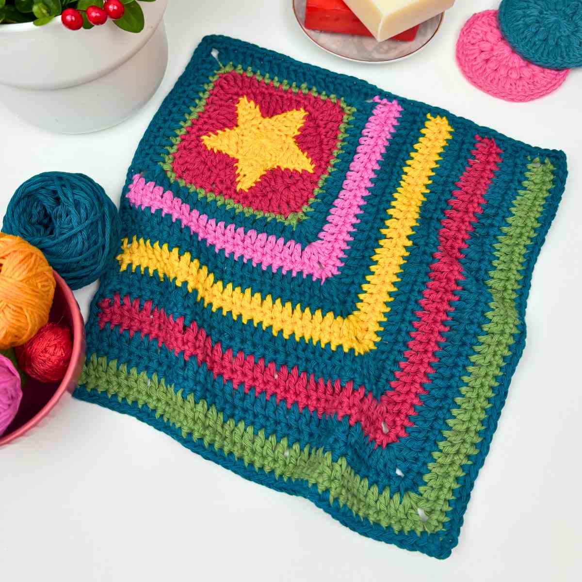 crochet washcloth made from free crochet dishcloth pattern, with a granny square corner featuring a bold yellow star.