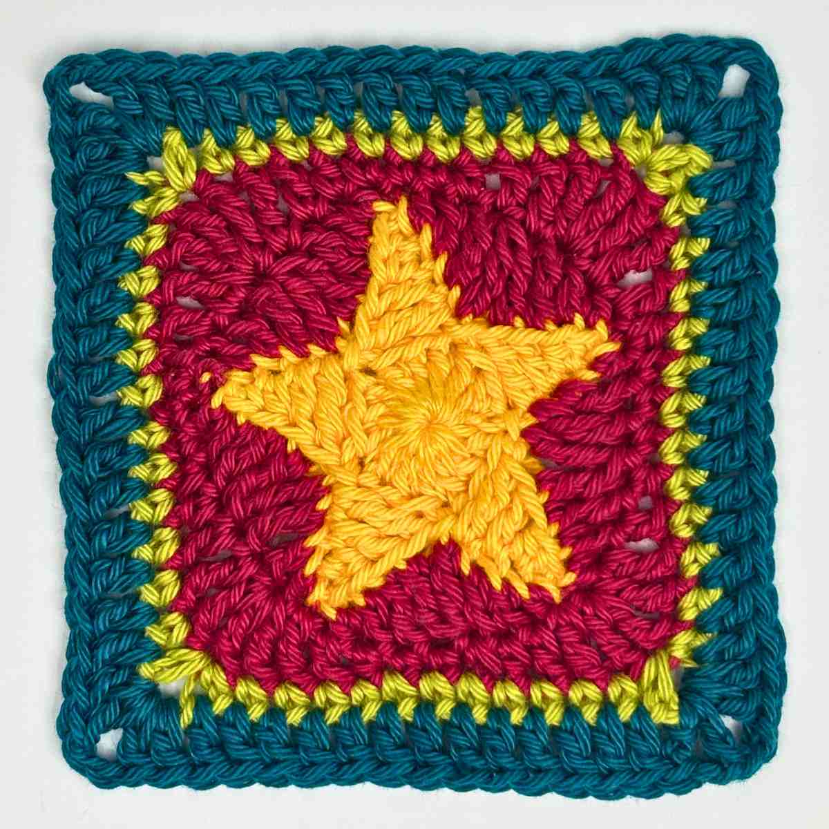 corner square of crochet washcloth made from free crochet dishcloth pattern, with a granny square featuring a bold yellow star.