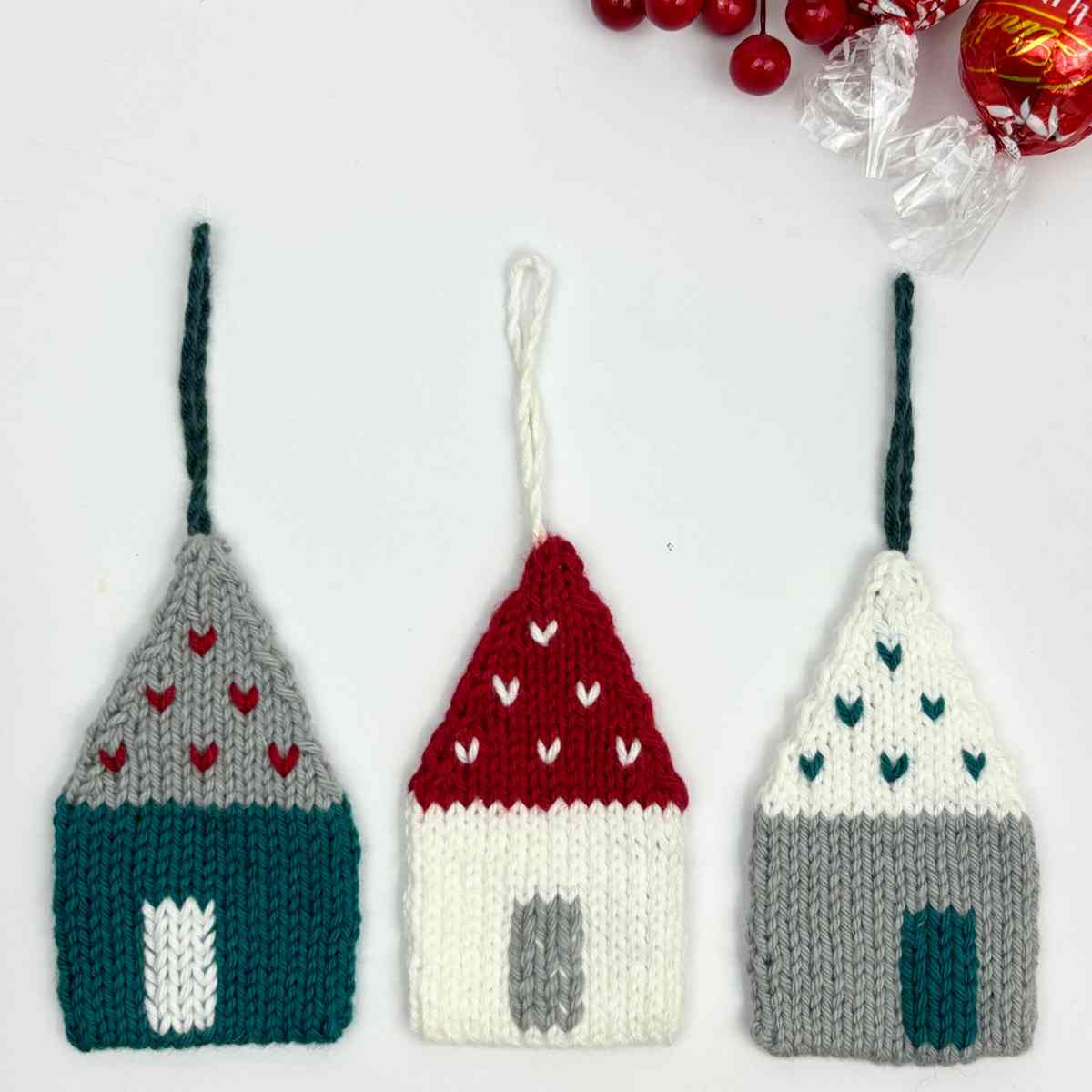 Three knitted houses made from free knitted house pattern. in Teal, White and Grey, with hanging loops.