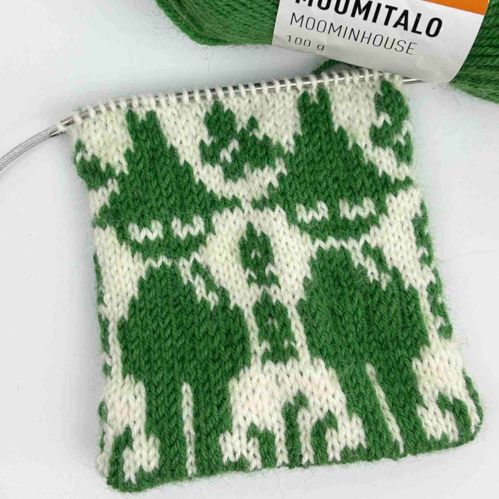 Knitted sock in the process of upcycling, with live stitches on the circular needles.