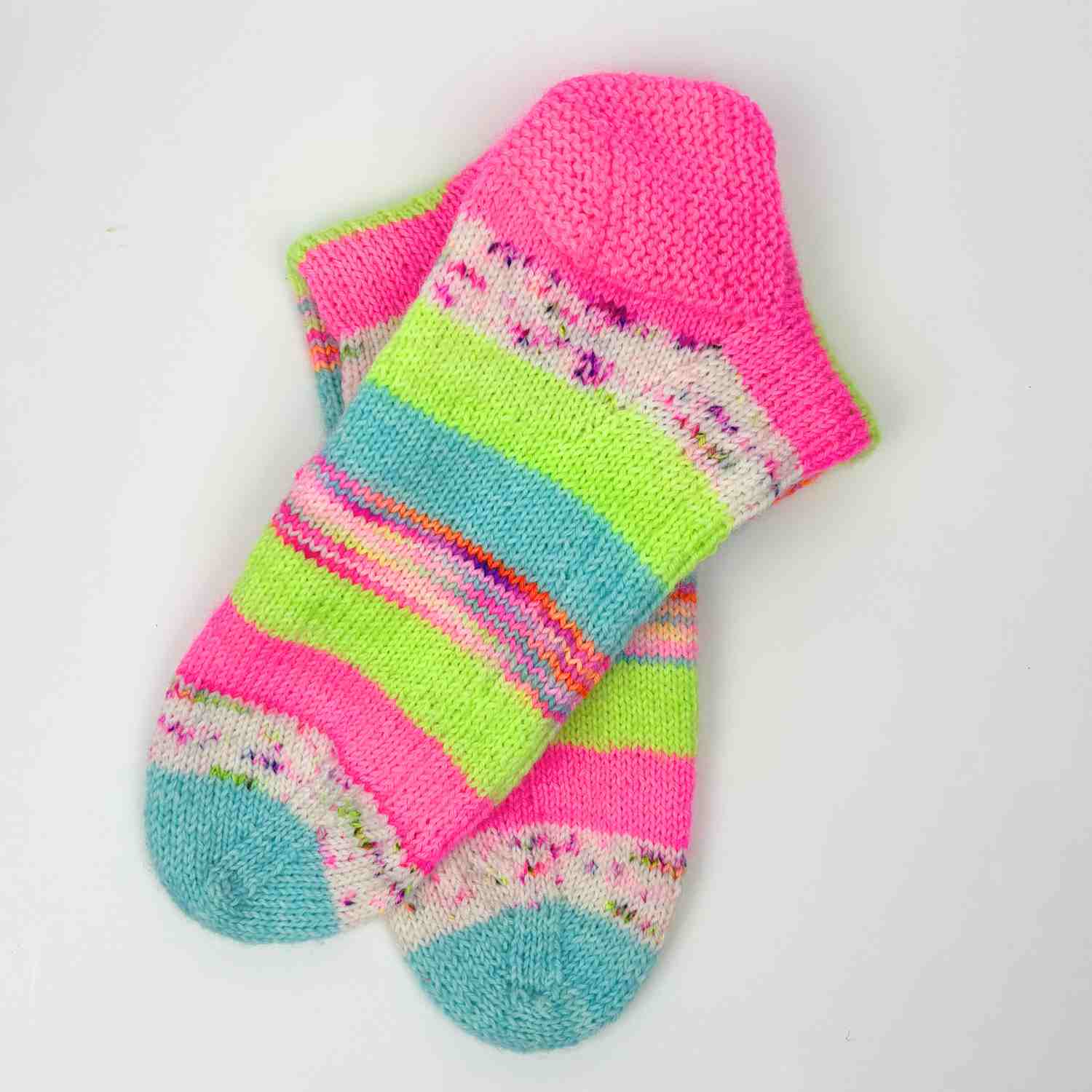 Knitted Stash Yarn Socks shown in scrap yarn, in bring pink, neon green and pale blues.