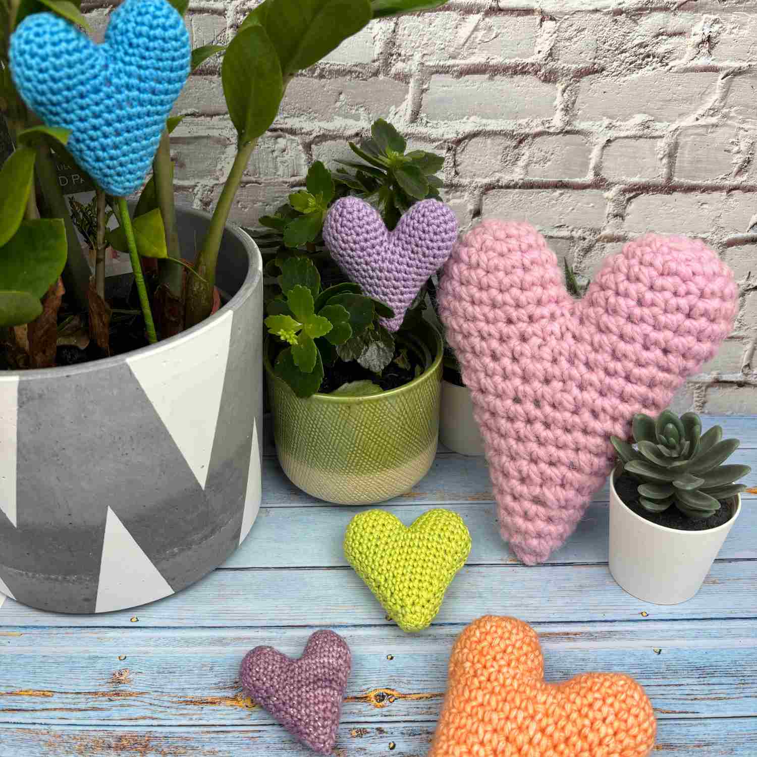 A selection of crochet hearts in different sizes, all made from the same free amigurumi heart pattern.