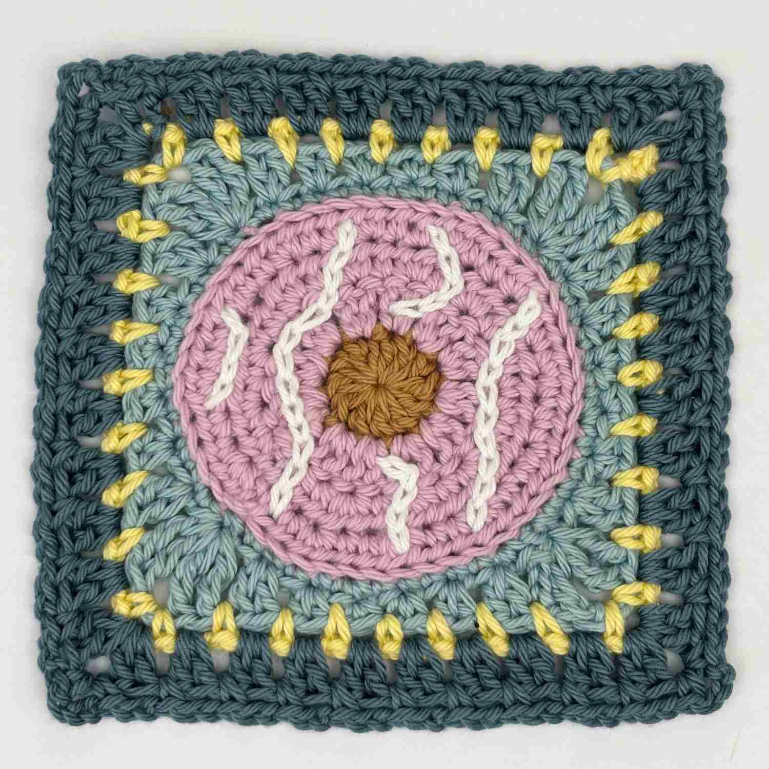 Party ring biscuit granny square with lilac party ring centre and white icing detail.