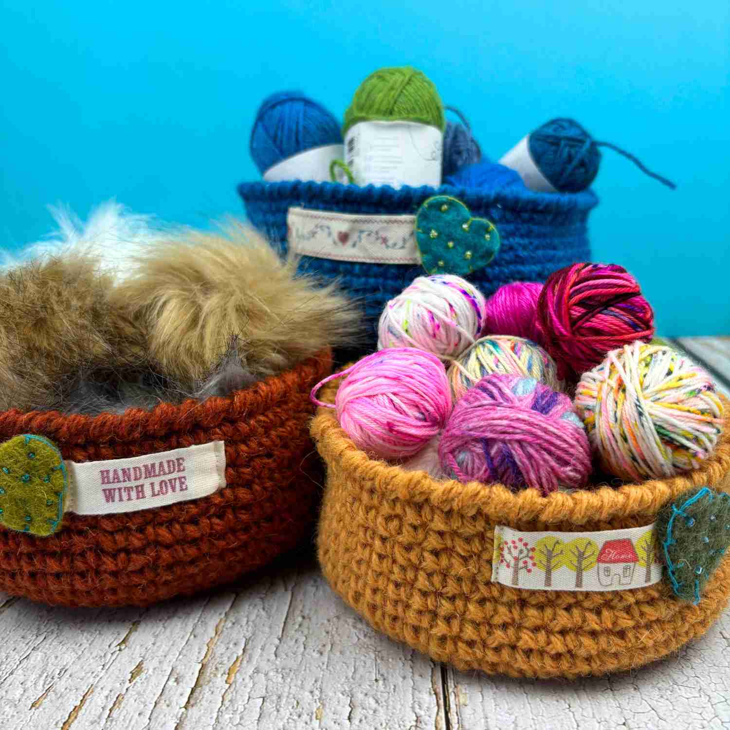 Three crochet bowls in earth colours, made from yarn stash oddments. filled with crafting supplies.