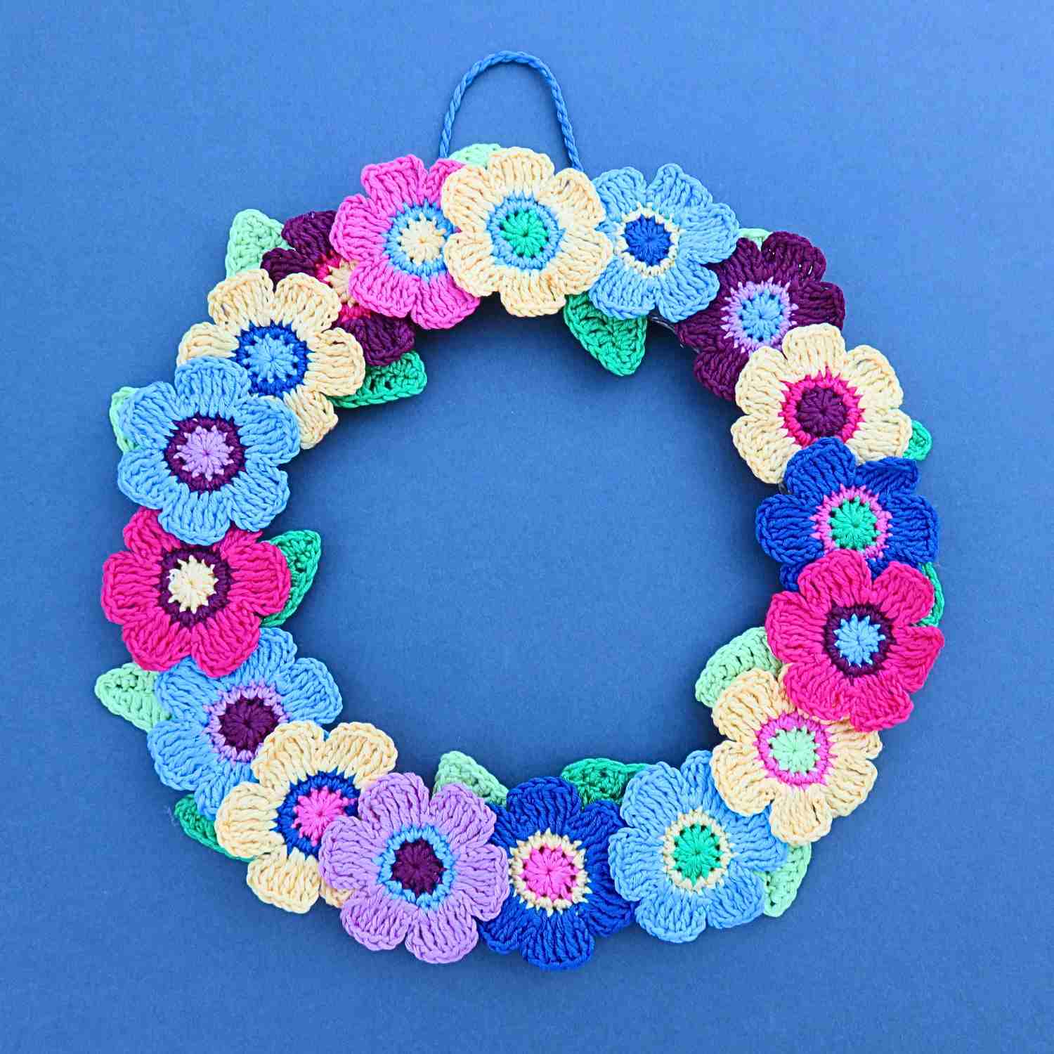 Crochet Flowers and Leaves around a flat wreath base, in cotton yarn