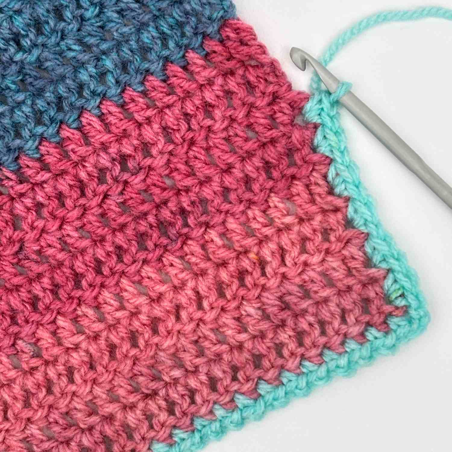 Corner of crochet baby cardigan showing edging to hem and front edge.
