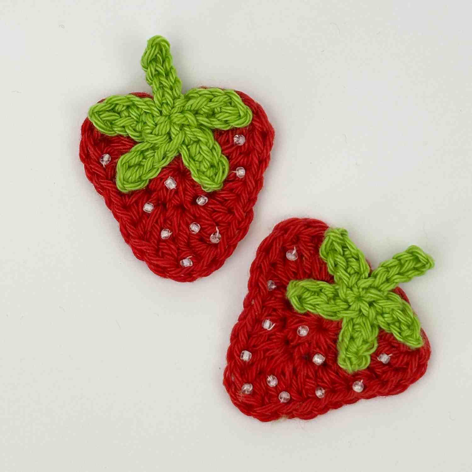 Strawberry Motif patch appliqué in red with green stalk and white seed beads.