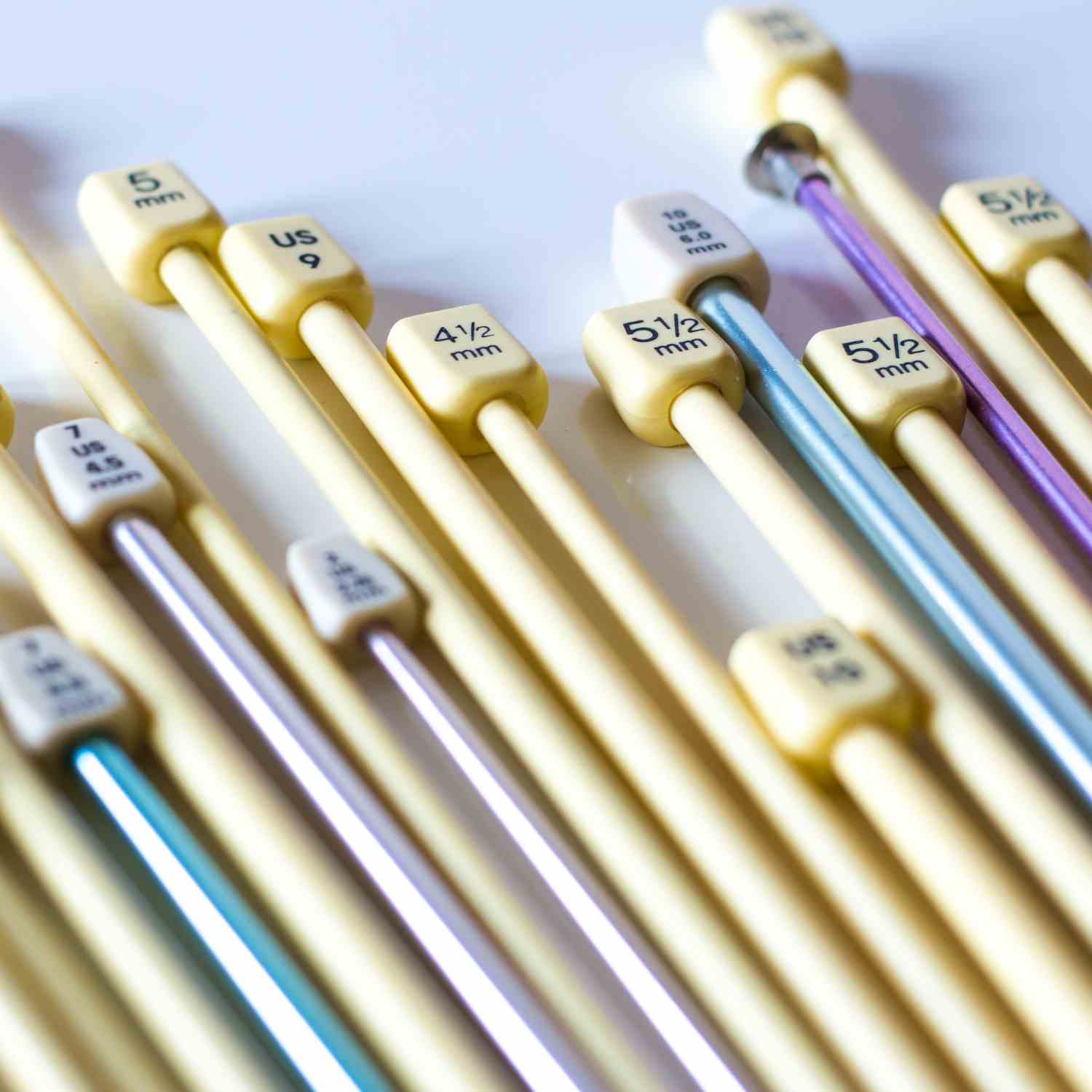 Straight knitting needles in plastic and metal, showing knitting needles sizes.