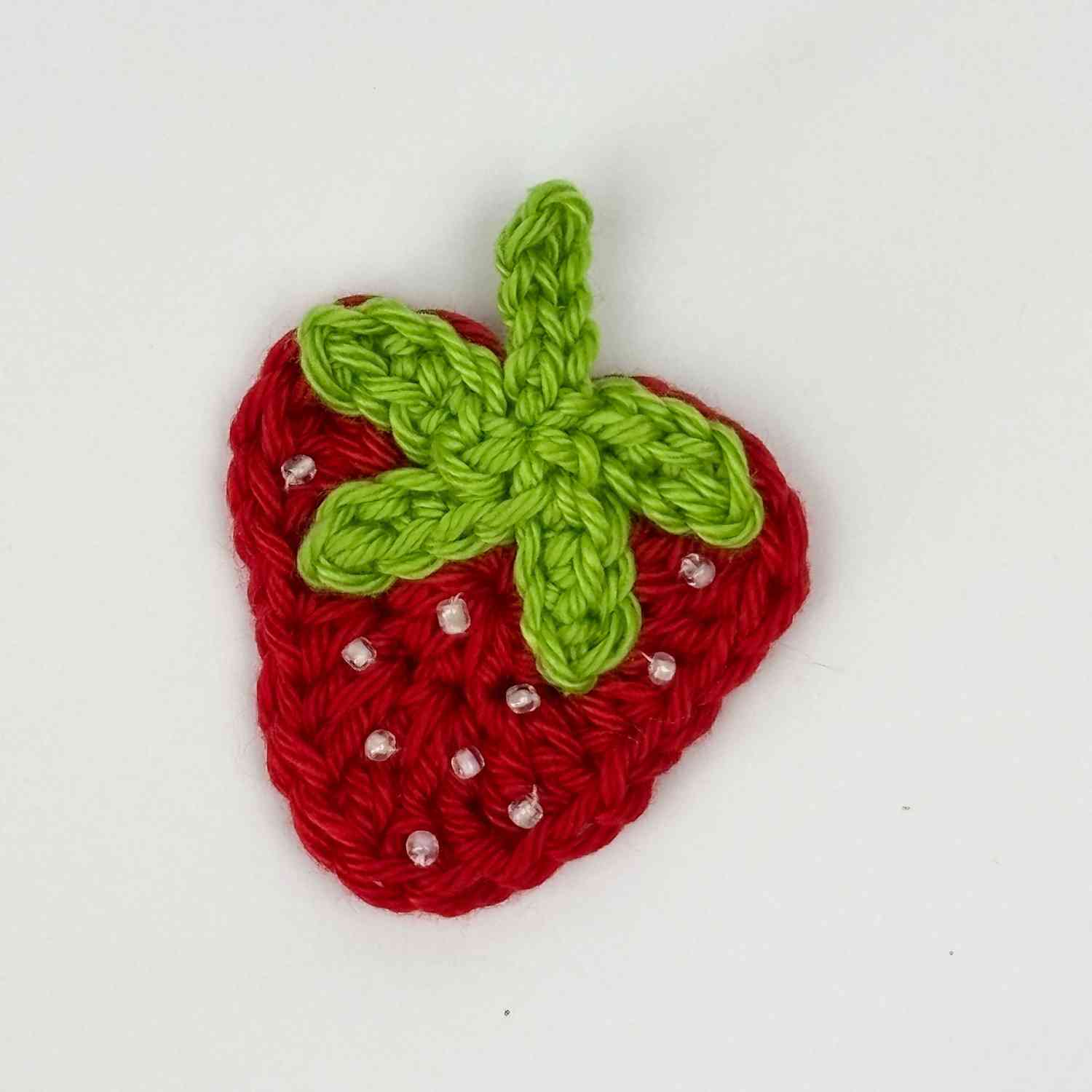 Strawberry Motif patch appliqué in red with green stalk and white seed beads.