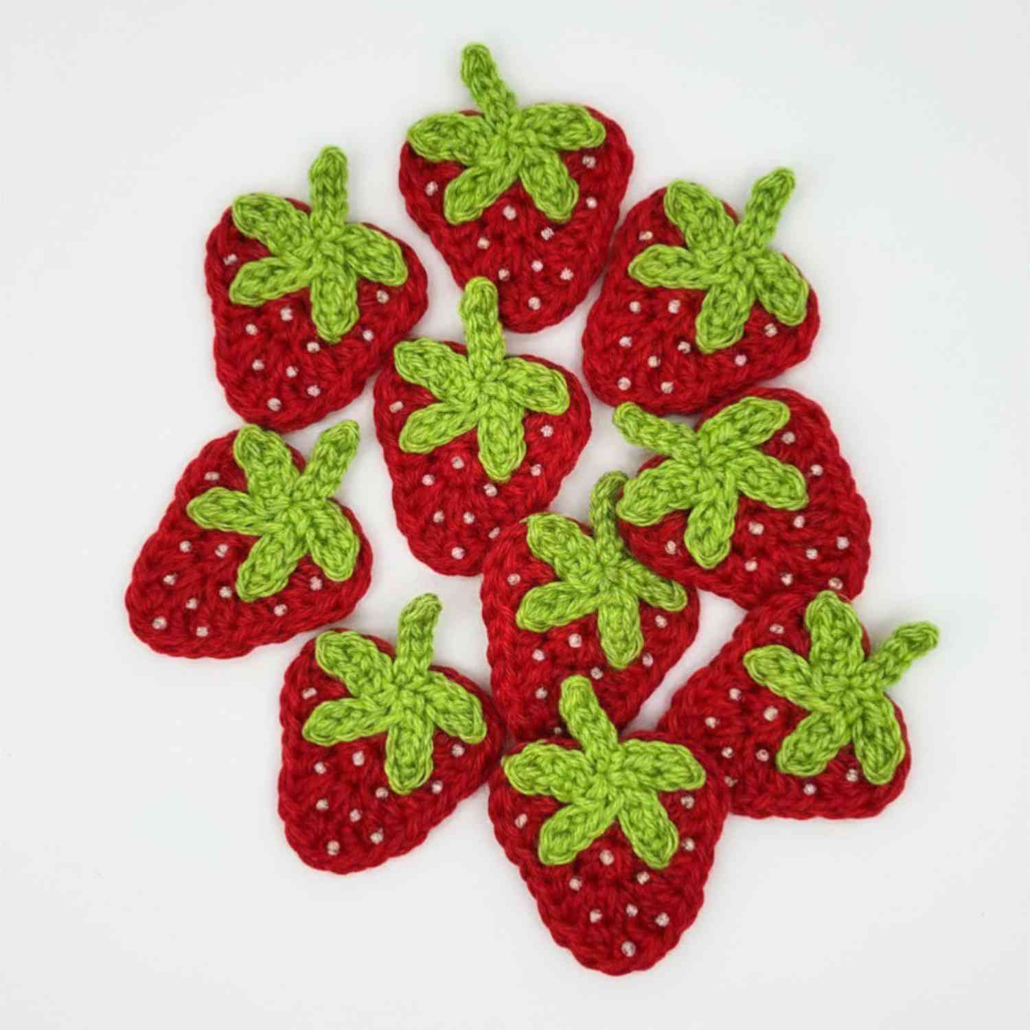 A collection of Strawberry Motifs in red with green stalk and white seed beads.