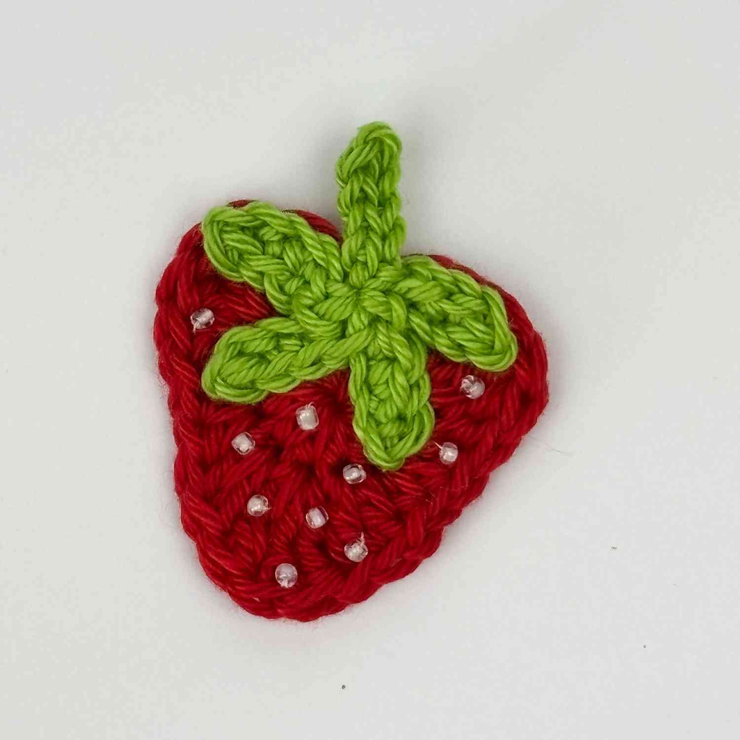 Strawberry Motif patch appliqué in red with green stalk and white seed beads.