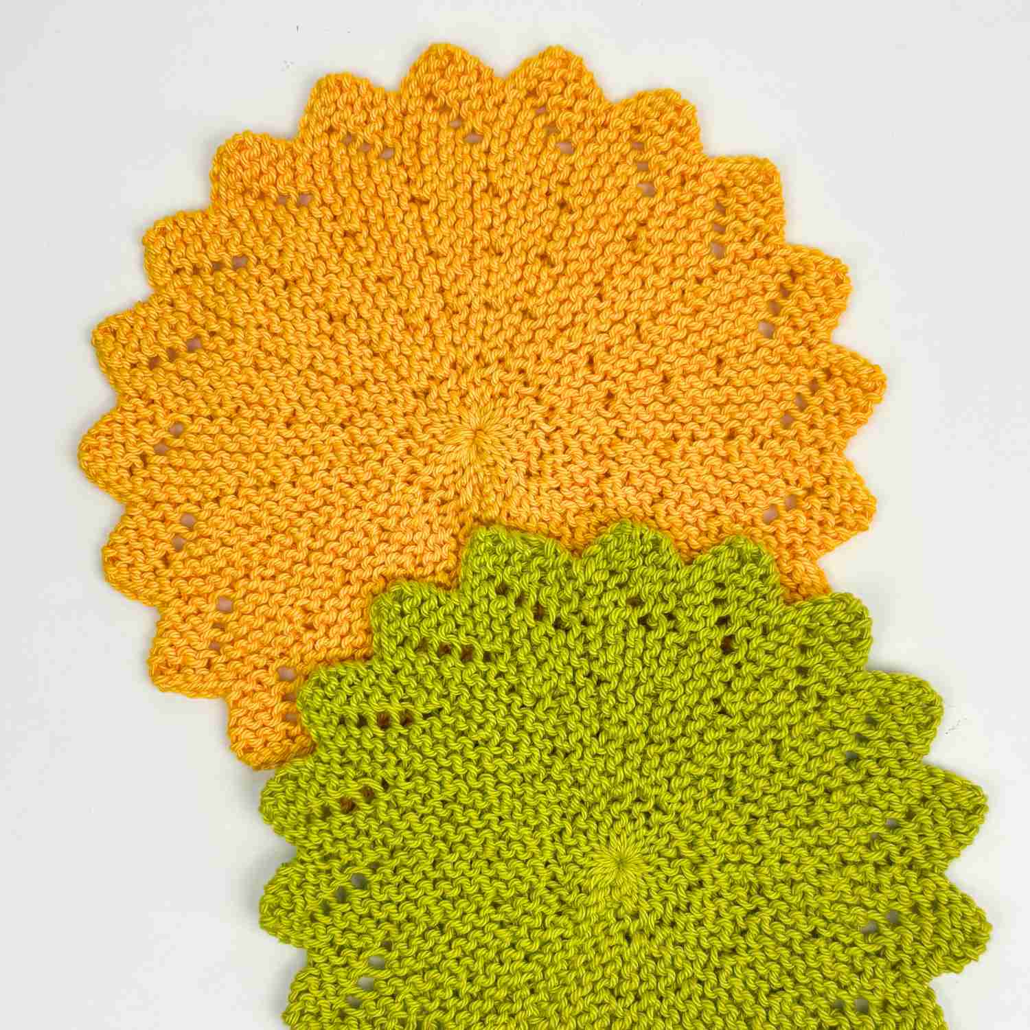 Knitted circle dishcloth pattern made in bright sunflower yellow yarn and pea green yarn. 
