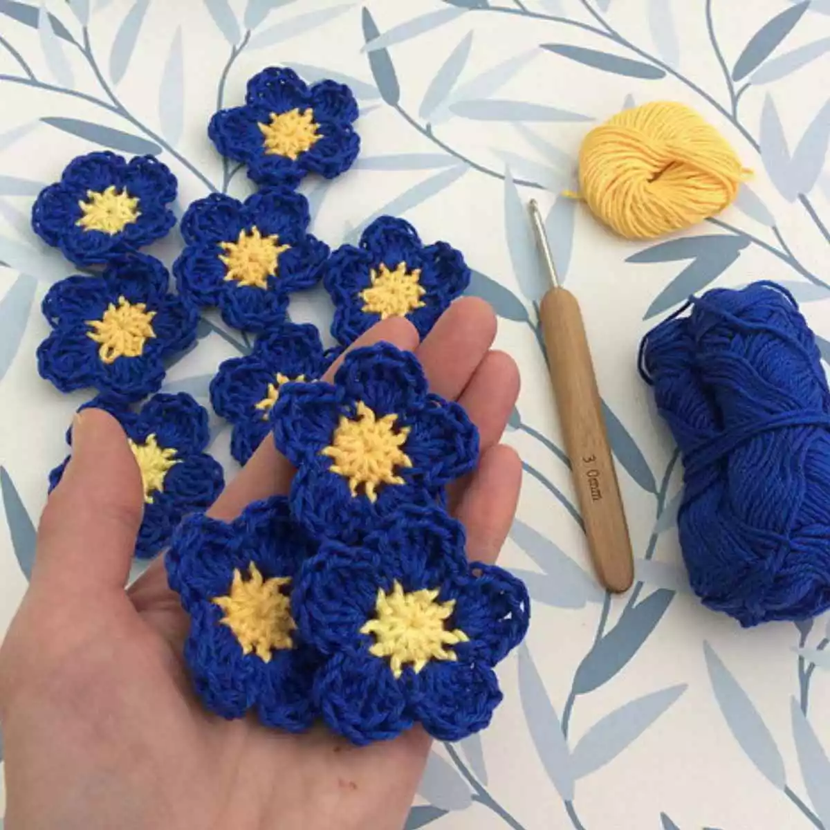 crochet flowers in blue and yellow to resemble forget-me-nots for Alzheimers Society.