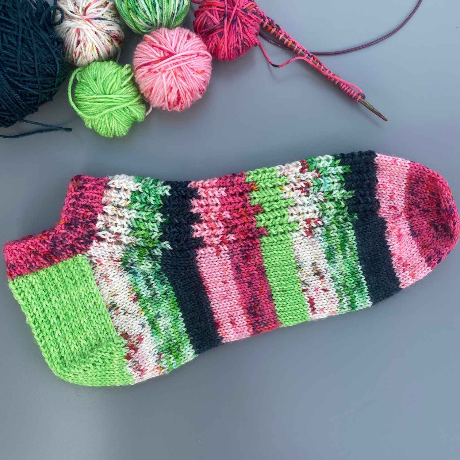 Short ankle socks knitted from free sock knitting pattern, using yarn stash oddments in watermelon shades