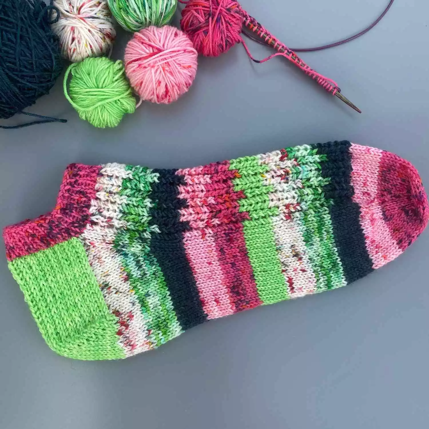 Short ankle socks knitted from free sock knitting pattern, using yarn stash oddments in watermelon shades